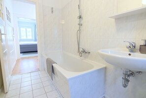A bathroom with a bathtub, a shower, and a sink. - Mountain View - The Donnerberg Mountain Resort (Altenberg)