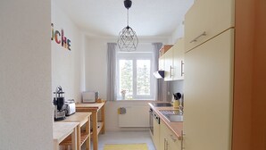 A compact kitchen with a window, a coffee machine, and a radiator.
