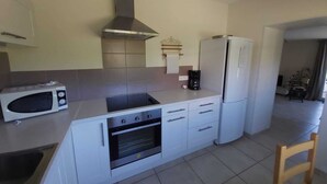 A compact kitchen with a microwave, stove, oven, and a coffee maker. - In the city or in the countryside! 2.7 km from the Valentré Bridge (PRADINES)