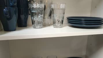 Une étagère avec divers objets en verre et assiettes.