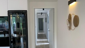 Une cuisine moderne dotée d’un four encastré et d’un couloir menant à une salle à manger.