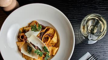 A plate of pasta with a fork and napkin on a table.