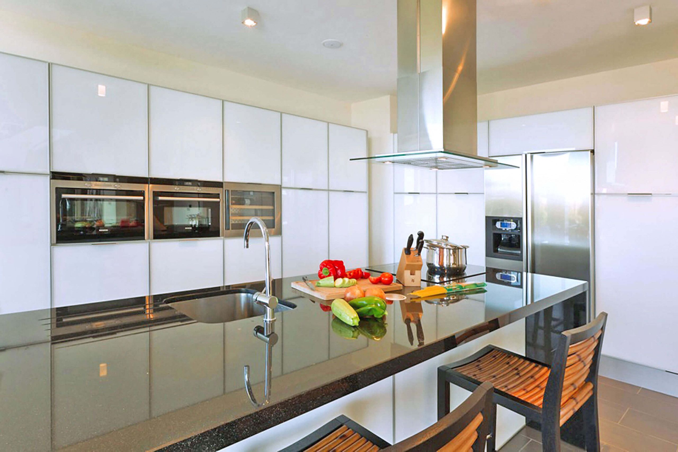 Una cocina moderna con una isla central, electrodomésticos de acero inoxidable y un salpicadero de vidrio.