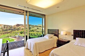 Ein Hotelzimmer mit zwei Betten, einem Balkon mit Blick auf die Stadt und einem großen Fenster.