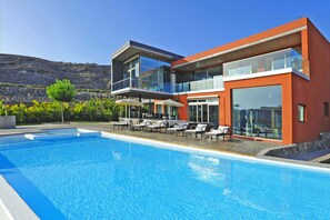 Ein modernes Hotel mit Pool, Außenbereich und Blick auf die Berge.