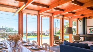 Un comedor con una mesa de madera dispuesta para una comida, un sofá y un televisor.