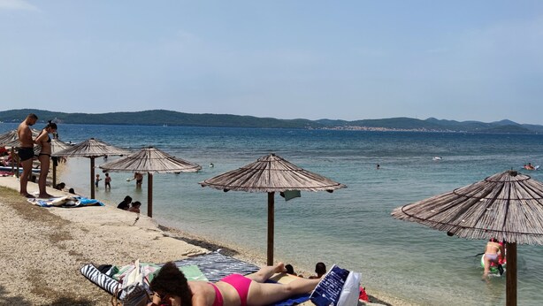 A beach with umbrellas and people relaxing. - Apartment Kristijan Sleeps 2 With Wi-fi (Zadar)
