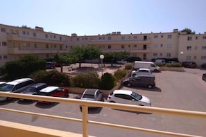 Un edificio de apartamentos de varios pisos con un estacionamiento.