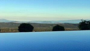 Una piscina con vistas a montañas y árboles lejanos.