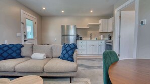 A modern kitchen with white cabinets, a stainless steel refrigerator, and a built-in oven. - Mango Street Inn Suite 3 (Fort Myers Beach)