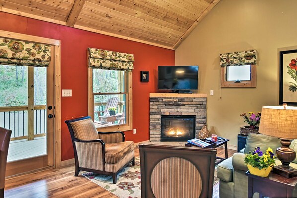 A cozy living room with a fireplace, a television, and a comfortable seating area. - Chanterelle Cabin w/Hot Tub, Fireplace - Near Asheville! (Weaverville)