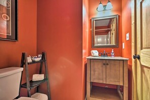 A bathroom with a wooden vanity, a mirror, and a shelf with toiletries. - Chanterelle Cabin w/Hot Tub, Fireplace - Near Asheville! (Weaverville)