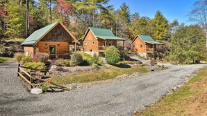 A cabin-style lodging with a gravel driveway and wooden fences.