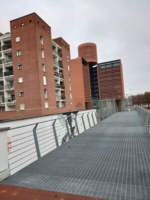 A pedestrian bridge with metal railings and a tiled walkway.
