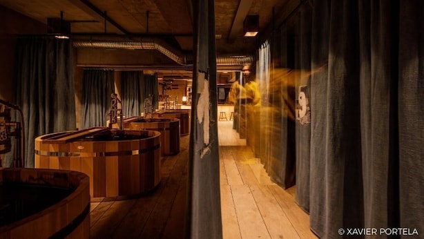 Un intérieur en bois, avec de grandes baignoires et un couloir.