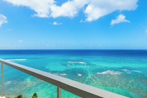 A clear view of the ocean with a balcony railing.