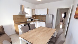 A compact kitchen with white cabinets, a wooden countertop, and a built-in microwave. - Beautiful 2-bed Apartment in Okrug Gornji (Okrug)