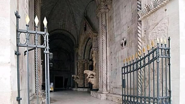 An arched doorway with intricate stone carvings and a metal gate with a decorative finial. - Beautiful 2-bed Apartment in Okrug Gornji (Okrug)