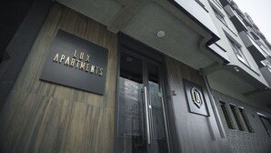 Entrada de un edificio con un letrero que dice 'LUX APARTMENTS'.