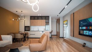 Una sala de estar moderna con un sofá, una mesa de centro y un televisor montado en la pared.