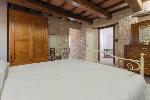 A bedroom with a wooden wardrobe, a bed, a chair, and a dresser. - Villa Costanzi: Beautiful country apartment! (Sigillo)