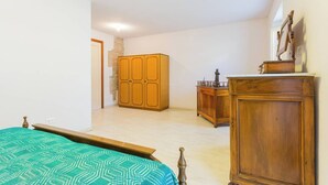 A bedroom with a bed, wooden wardrobe, and a dresser.
