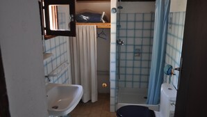 Un baño pequeño con lavabo, inodoro y ducha.