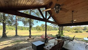 A covered outdoor area with wooden furniture, a table, and a bench. - Camplee - 50 Acres of Freedom (Zavalla)