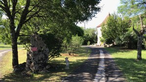 A gravel path leading through a park with trees and a statue. - Rent this charming furnished studio near Rocamadour and Padirac  (Gramat)