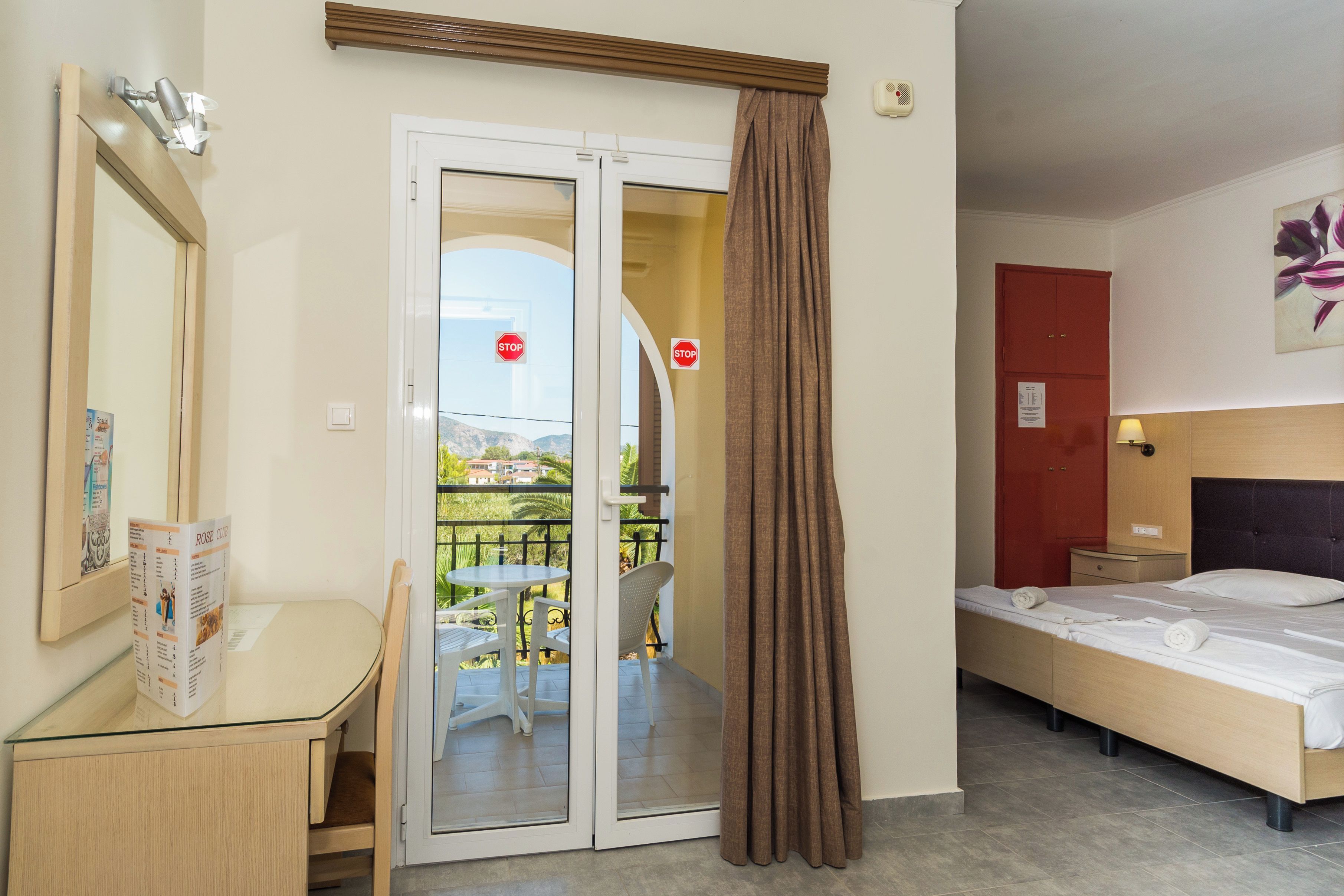 Une chambre d’hôtel comprenant un lit, un bureau, une chaise, une salle de bain et un balcon avec vue.