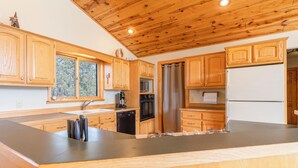 A kitchen with wooden cabinets, a stainless steel refrigerator, a microwave, and a dishwasher.