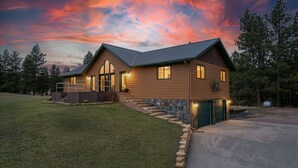 A two-story house with a stone foundation, a covered porch, and a garage.