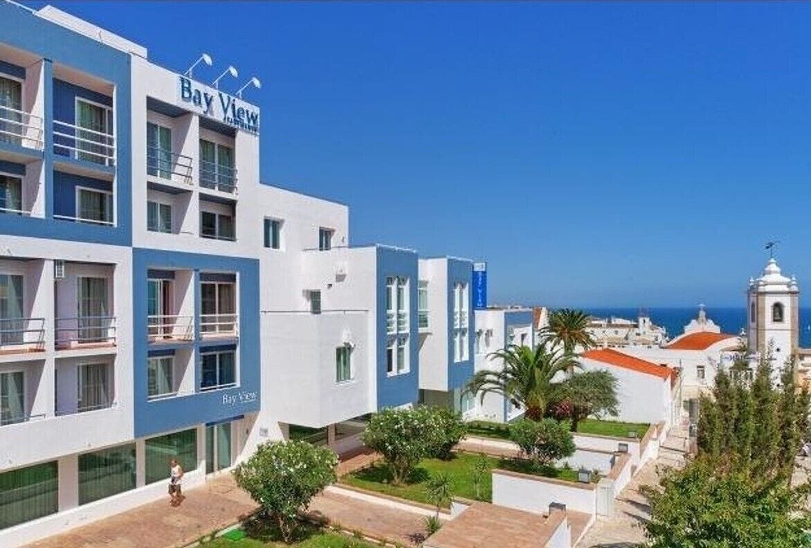 A hotel named Bay View with a modern design, featuring balconies and a view of the sea.