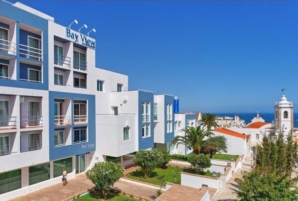 A hotel named Bay View with a modern design, featuring balconies and a view of the sea.