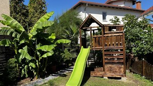 Una estructura de juego de madera con un tobogán en un patio trasero.