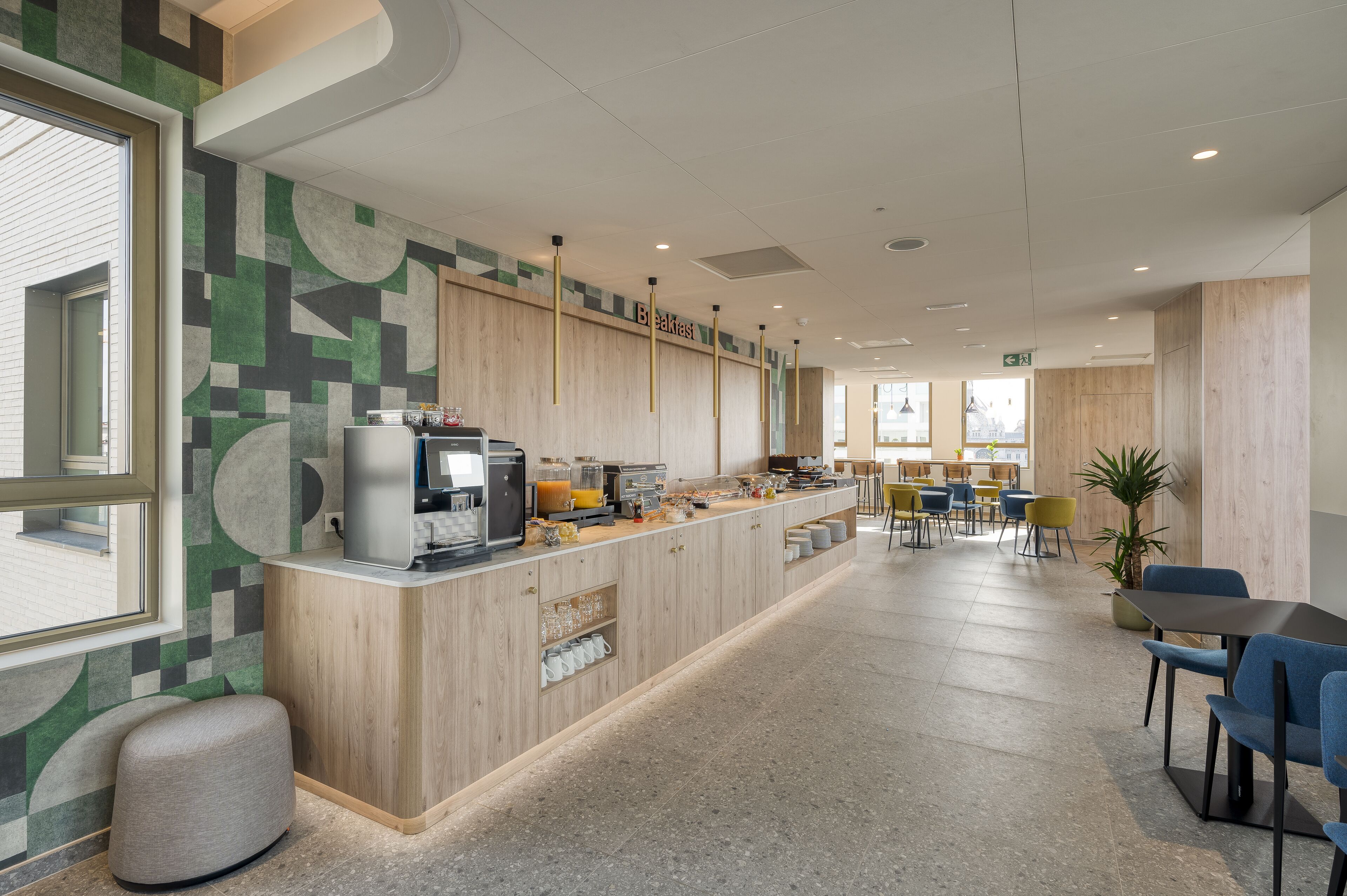 A modern breakfast area with a counter, seating, and a view of the outside.