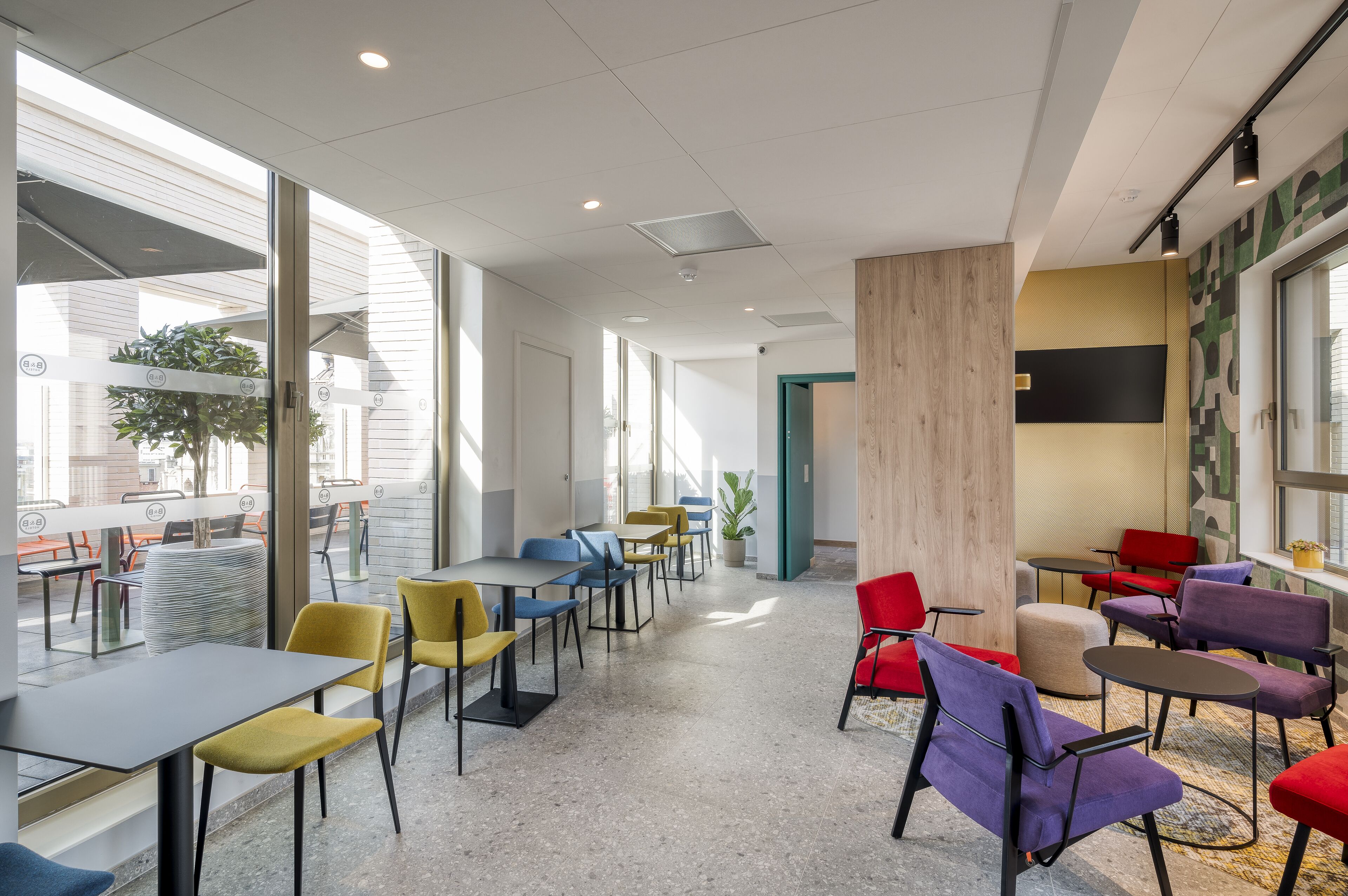Een moderne ruimte binnenshuis met tafels en stoelen, geschikt voor dineren of vergaderingen.