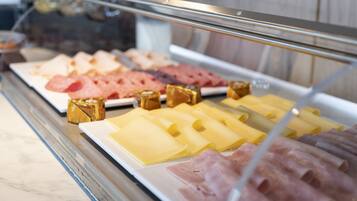 A deli counter with various meats and cheeses displayed behind a glass case.