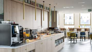 Ein Frühstücksbuffet mit Kaffeeautomat, Saftspendern und verschiedenen Speisen.