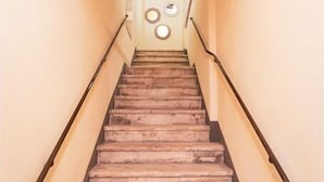 Eine Treppe mit hölzernem Geländer und einer beigen Wand mit runden Wandverzierungen.