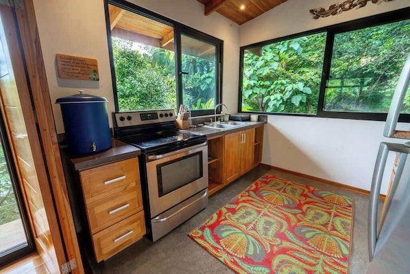 A compact kitchen with wooden cabinets, a stove, and a sink.