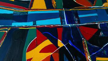 A close-up of a colorful abstract painting with intersecting lines and shapes.