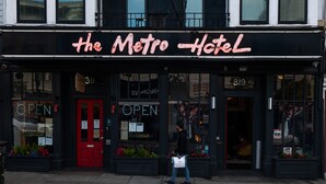 The exterior of the Metro Hotel with a red door, a neon sign, and a visible room number 319. - The Metro Hotel (San Francisco)