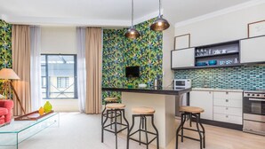 Une cuisine moderne dotée d’un îlot central, de tabourets de bar, d’un four à micro-ondes et d’une cuisinière.