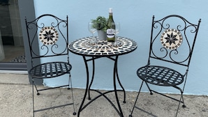 A small round table with a mosaic tile top, flanked by two chairs with decorative backs. - Farm House - Sleeps 7 - Garden - Parking (Kinsale)