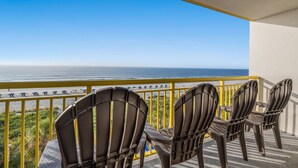 A balcony with three Adirondack chairs facing a beach. - Bay Watch 415-3BR/3BA Oceanfront Condo in North Myrtle Beach (North Myrtle Beach)