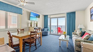 A spacious living area with a balcony, a dining table, and a sofa. - Bay Watch 611-2BR/2BA Oceanfront Condo in North Myrtle Beach (North Myrtle Beach)