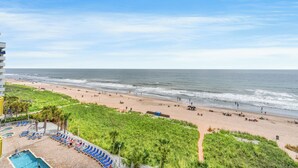 A beach view from a hotel balcony with a pool and lounge chairs. - Bay Watch 611-2BR/2BA Oceanfront Condo in North Myrtle Beach (North Myrtle Beach)