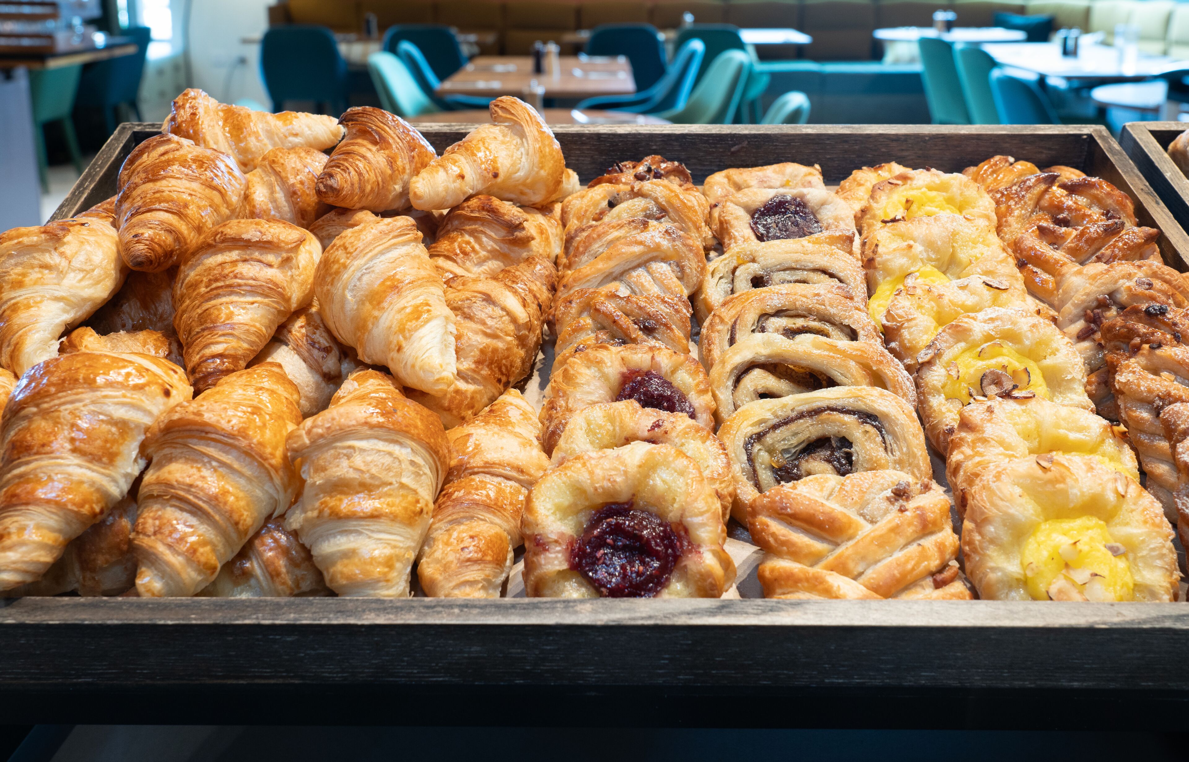 Un plateau contenant un assortiment de viennoiseries, notamment des croissants et des pâtisseries aux fruits.