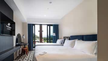 Una habitación de hotel con cama, escritorio, televisión y vistas al exterior.